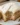 Delicious banana cake with cream cheese frosting on a rustic wooden table.
