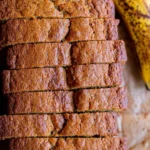 Slice of homemade moist banana bread on a wooden table