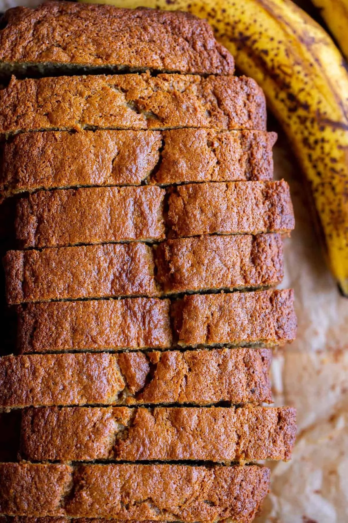 Slice of homemade moist banana bread on a wooden table
