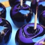 Delicious black swirl candy apples with a shiny glaze, perfect for Halloween treats