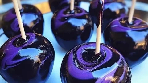 Delicious black swirl candy apples with a shiny glaze, perfect for Halloween treats