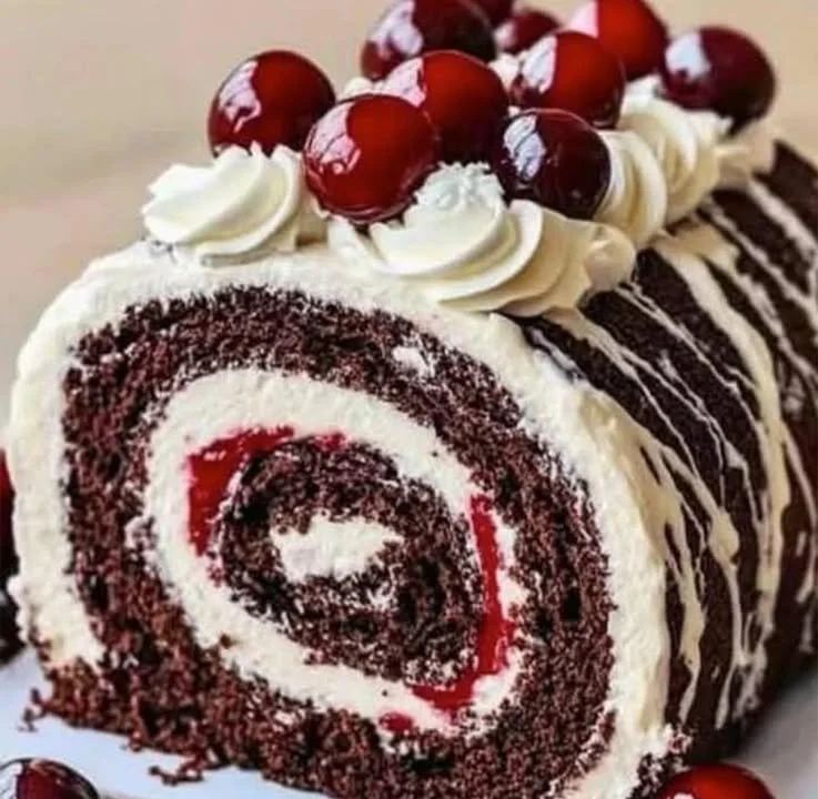 Delicious Black Forest Cream Roll Cake with cherries and whipped cream
