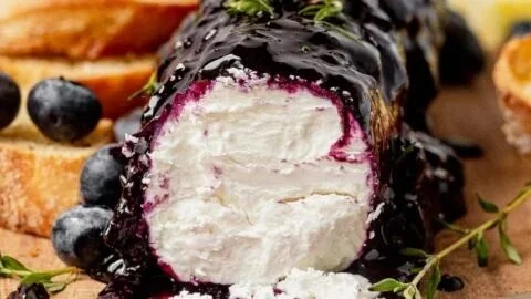 Blueberry goat cheese on a serving platter with fresh berries.
