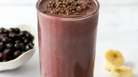 Delicious cacao smoothie in a glass with a sprinkle of cacao powder on top