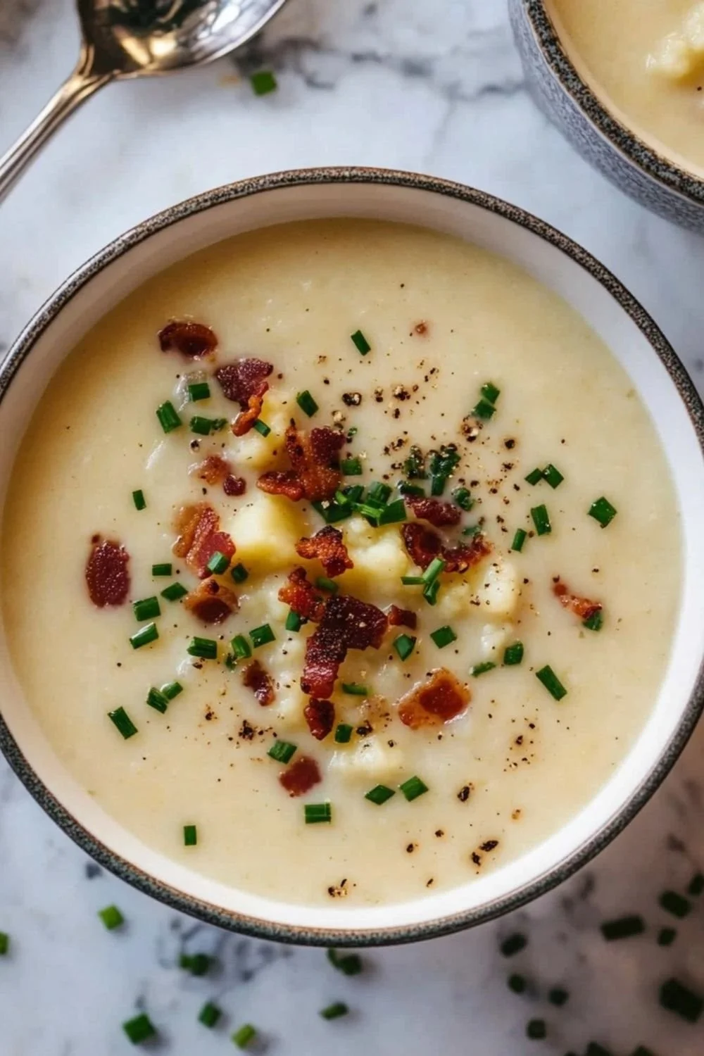 Bowl of creamy cauliflower potato soup garnished with herbs