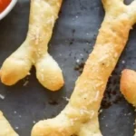 Cheesy Halloween breadstick bones shaped like spooky skeletons
