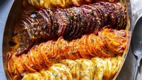 Cheesy root vegetable gratin topped with melted cheese and herbs