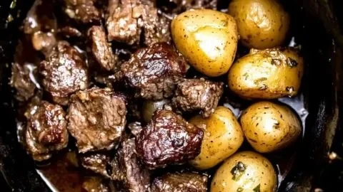 Crockpot garlic butter beef bites served with potatoes