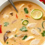 Bowl of Crockpot Thai Coconut Chicken Soup garnished with herbs