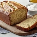 Slice of easy moist banana bread on a wooden cutting board