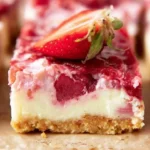 Easy strawberry cheesecake bars topped with fresh strawberries on a white plate.