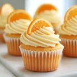 Fluffy orange cupcakes topped with orange frosting and zest.