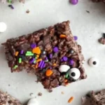 Colorful Halloween Rice Krispie Treats shaped like pumpkins and ghosts