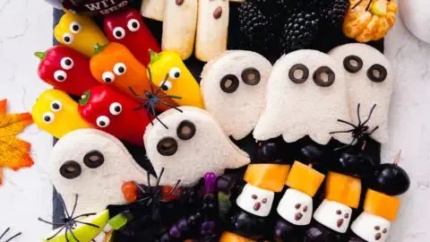 Colorful Halloween snack board for kids with spooky treats and festive decor.