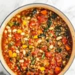 Bowl of healthy quinoa vegetable soup with fresh vegetables and herbs