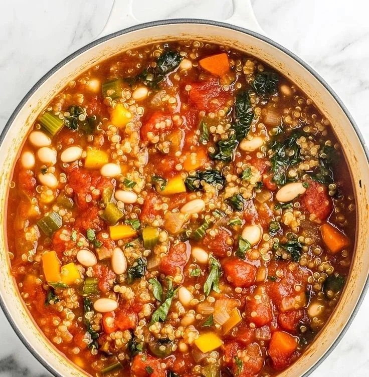 Bowl of healthy quinoa vegetable soup with fresh vegetables and herbs
