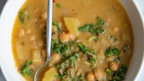 A bowl of high-protein chickpea soup with fresh herbs and spices.