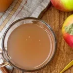 Homemade apple cider brewing process with fresh apples in a pot