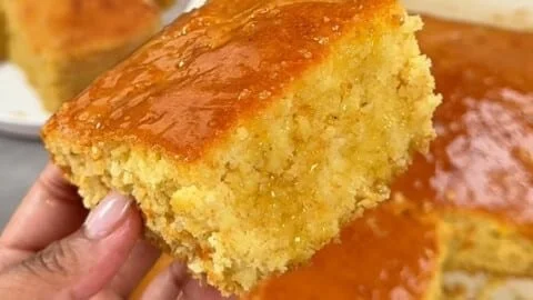 A delicious slice of Honey Butter Cornbread served with honey and butter.