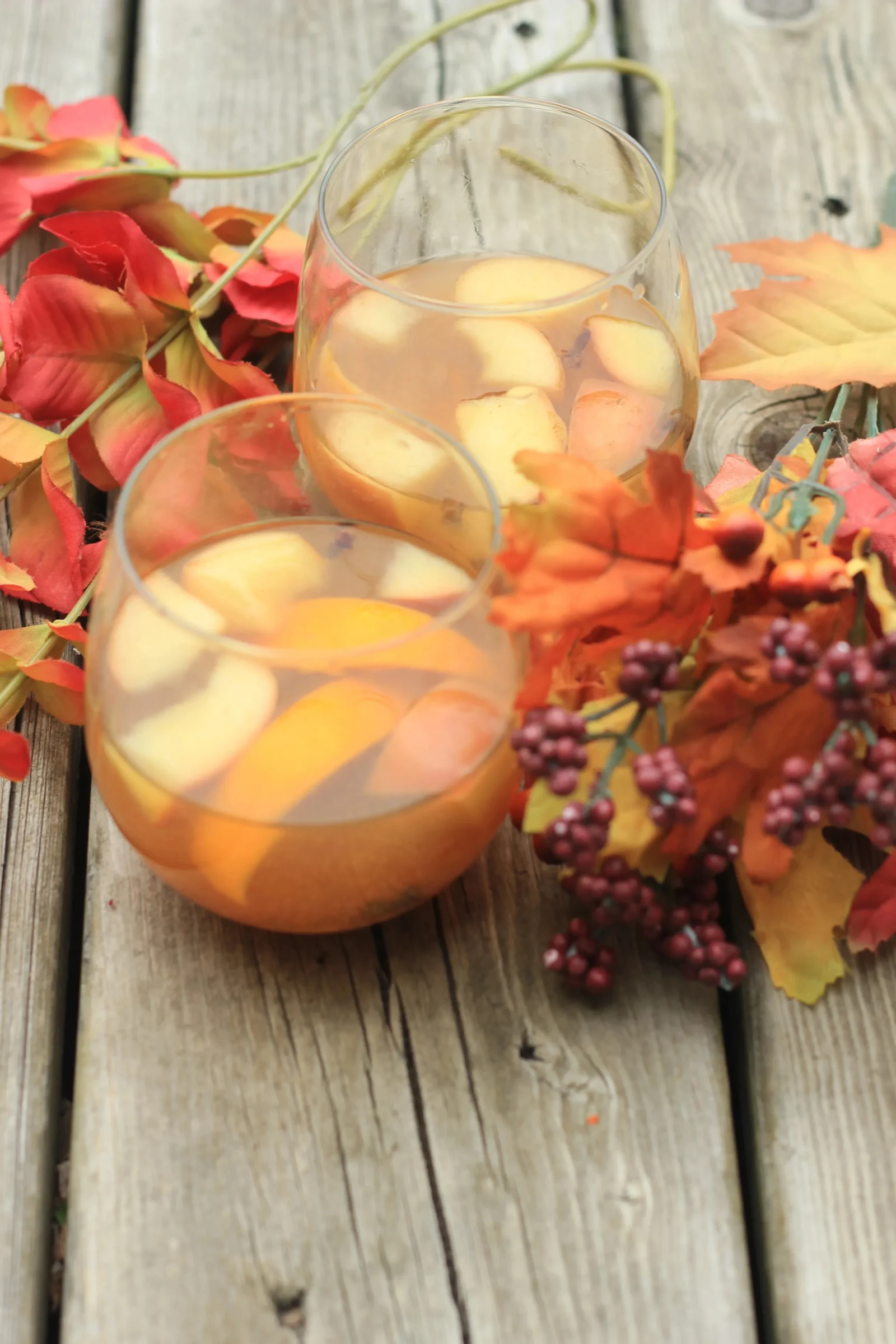 Crock pot filled with hot mulled apple cider sangria, garnished with spices and fruits.