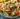 Mediterranean salad with lemony shrimp, avocado, and tomatoes garnished fresh herbs
