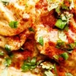 Melted chicken dish with herbs and cheese on a plate
