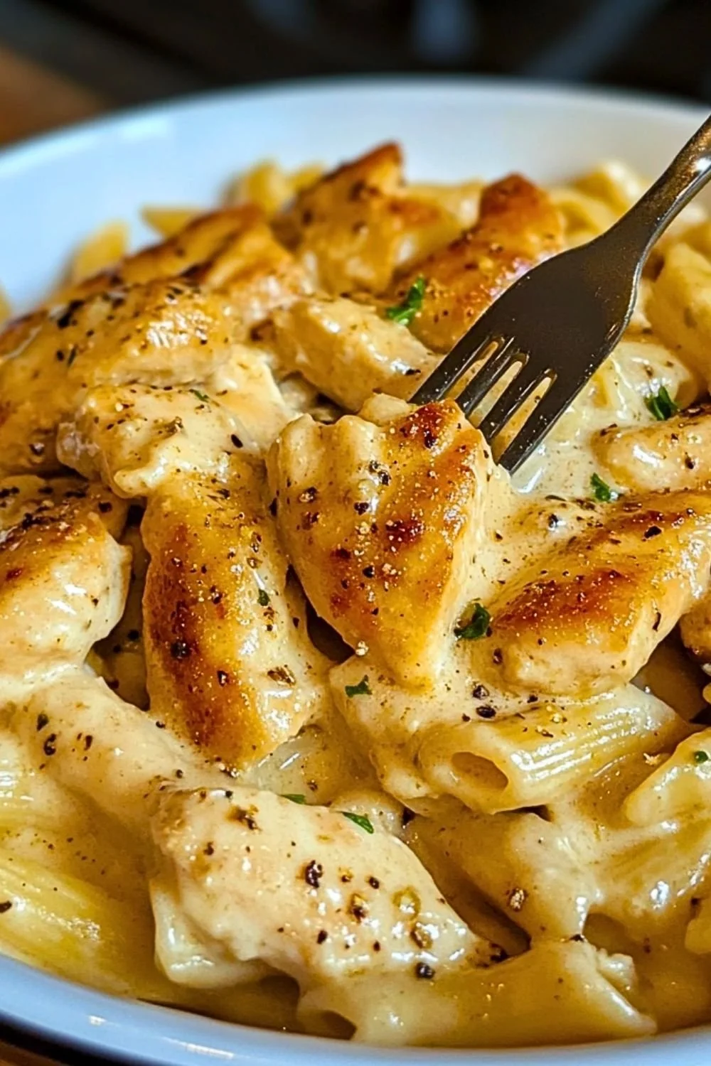 One pot garlic parmesan chicken pasta served in a bowl with herbs on top.