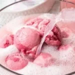 Delicious Pink Sherbet Punch served in a festive glass garnished with fruit