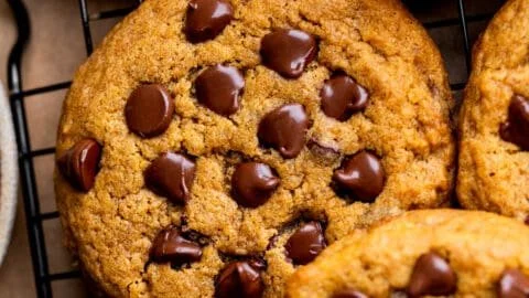 Freshly baked pumpkin chocolate chip cookies on a cooling rack.