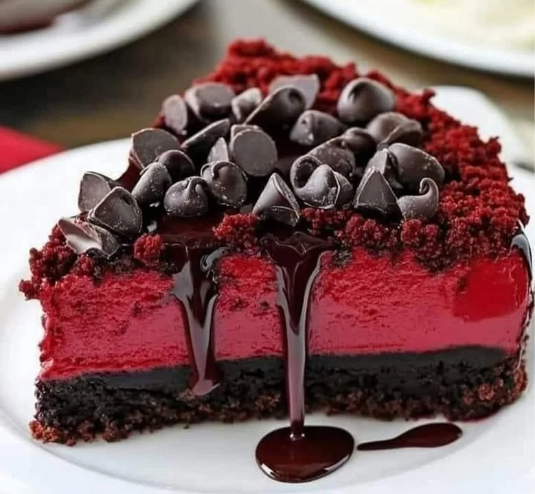 Slice of rich Red Velvet Cheesecake topped with cream cheese frosting