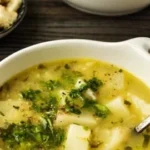 Delicious bowl of roasted garlic potato soup garnished with herbs