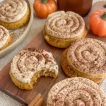 Soft pumpkin cookies drizzled with cinnamon frosting on a white plate.