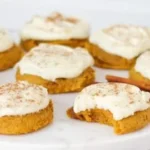 Soft pumpkin cookies with cream cheese frosting on a plate