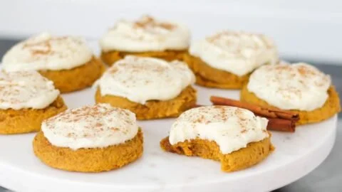 Soft pumpkin cookies with cream cheese frosting on a plate