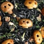 Bowls of spooky pasta decorated for Halloween, featuring ghost and pumpkin shapes.