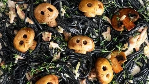 Bowls of spooky pasta decorated for Halloween, featuring ghost and pumpkin shapes.