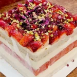 Delicious strawberry cream two-layer square cake with fresh strawberries on top.