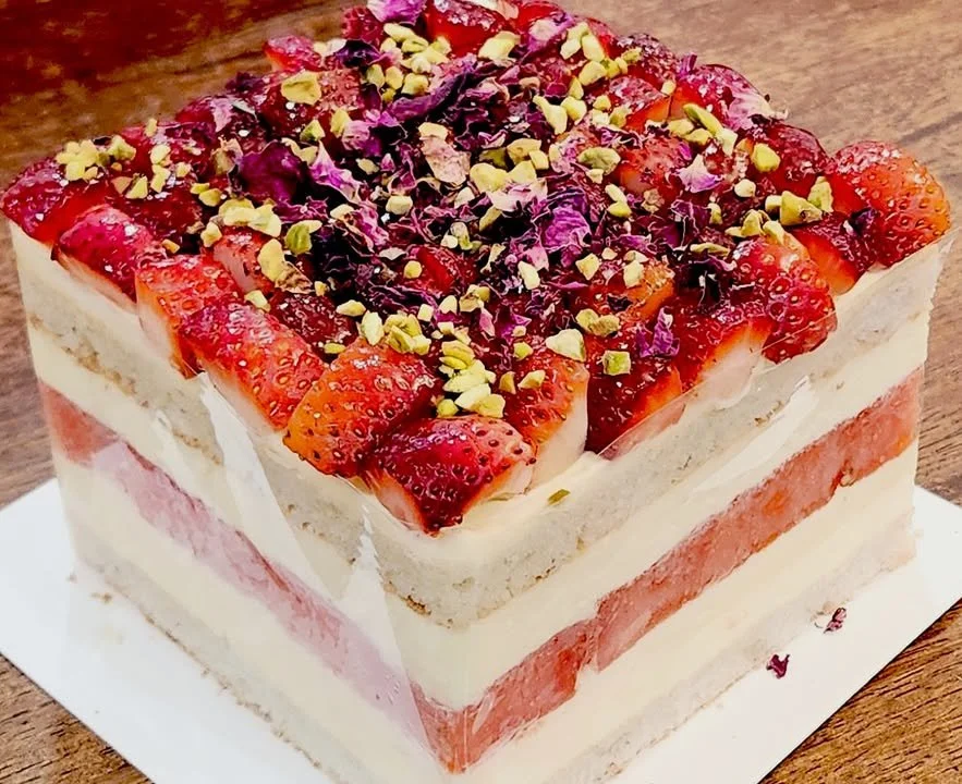 Delicious strawberry cream two-layer square cake with fresh strawberries on top.