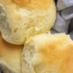 Freshly baked Texas Roadhouse Rolls with buttery glaze on a plate.