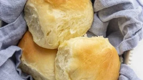 Freshly baked Texas Roadhouse Rolls with buttery glaze on a plate.