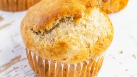 Vegan banana muffins baked golden brown with fresh bananas and nuts on a plate