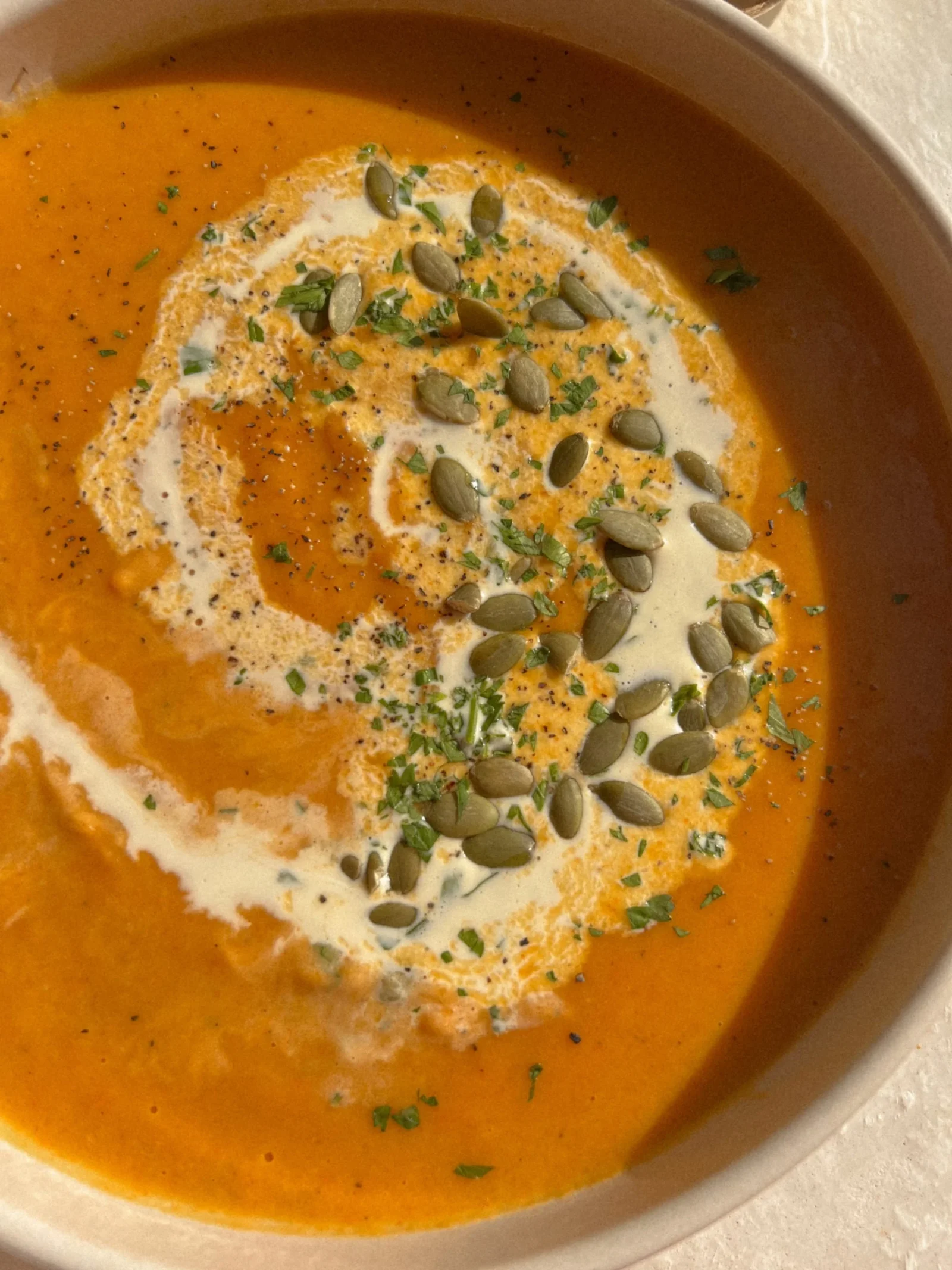 Vegan roasted butternut squash soup with carrots and coconut in a bowl