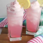 Refreshing whipped pink lemonade served in a glass with lemon slices