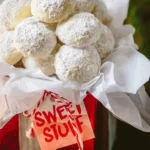 Homemade Almond Snowball Cookies dusted with powdered sugar on a white plate