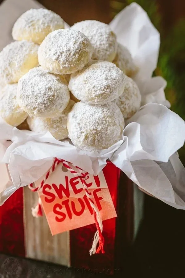 Homemade Almond Snowball Cookies dusted with powdered sugar on a white plate