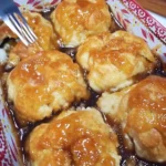 Delicious baked apple dumplings served with caramel sauce and a scoop of ice cream.