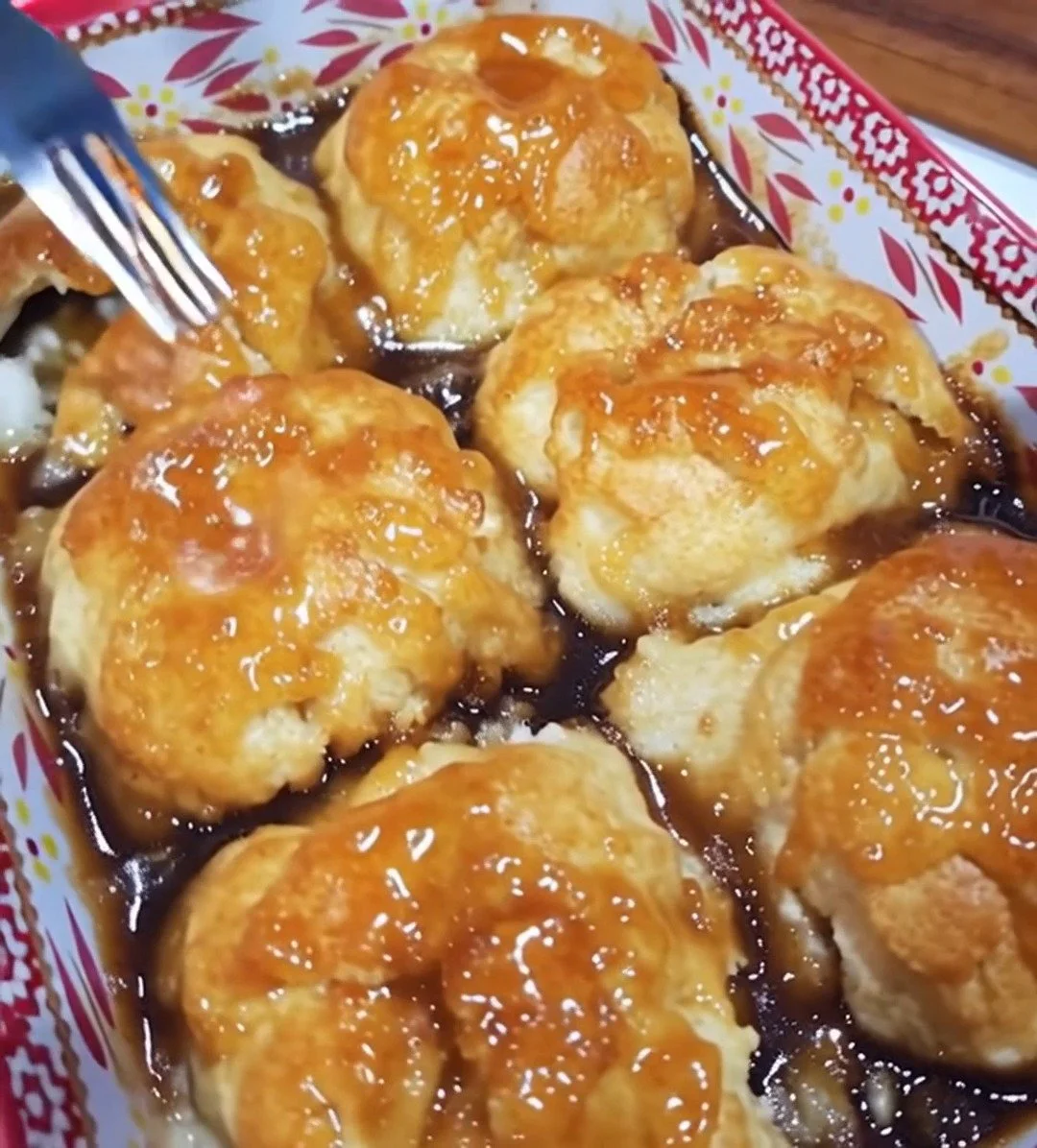 Delicious baked apple dumplings served with caramel sauce and a scoop of ice cream.