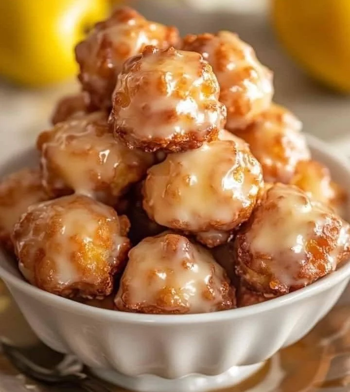 Delicious homemade apple fritter bites topped with glaze on a plate.