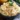 Bowl of deviled egg pasta salad with toppings and herbs