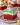 Delicious Christmas Red Velvet Poke Cake topped with festive cream and sprinkles.